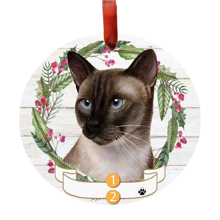 Round holiday ornament with a Siamese cat face centered in a festive green and red wreath decoration