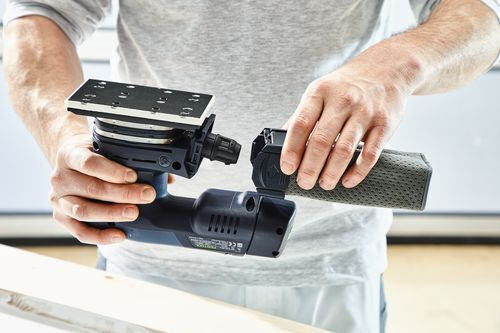 Person installing a rechargeable battery into a cordless orbital sander for home improvement tasks