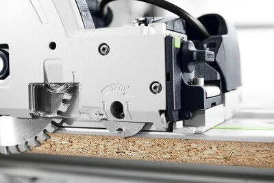 Close-up view of plunge cut track saw cutting through wood panel on guide rail for precise home improvement tasks