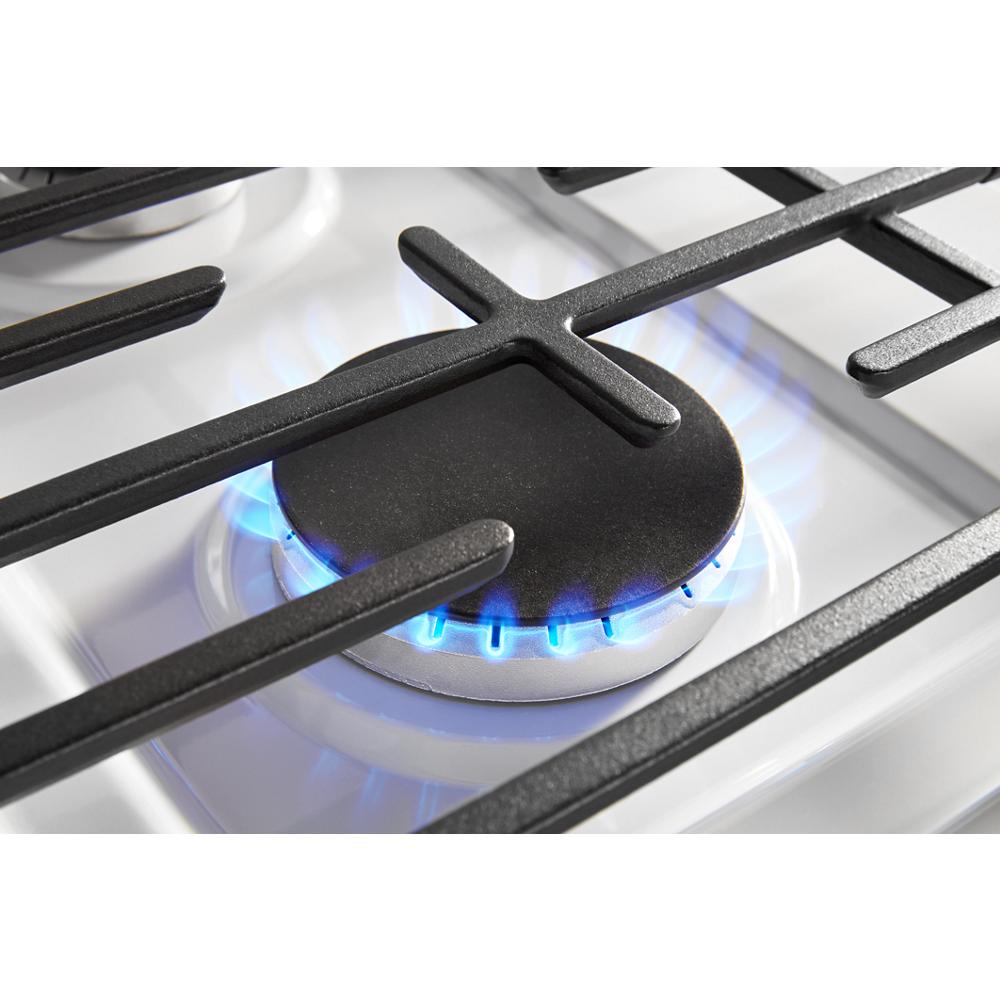 Close-up of a lit burner with blue flame on a white freestanding gas range in kitchen appliance collections