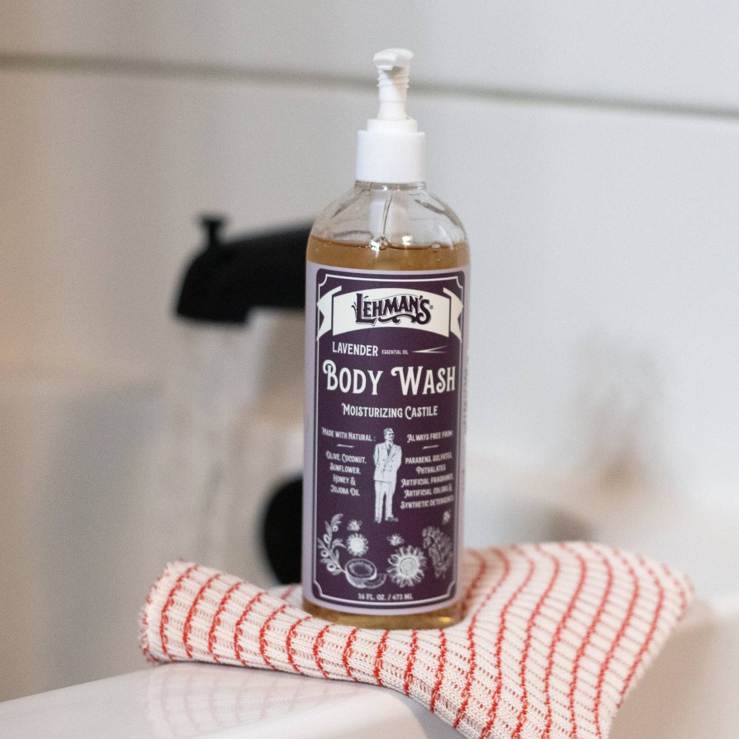 Clear pump bottle of lavender scented castile body wash on striped cloth in Health & Beauty collection under $50