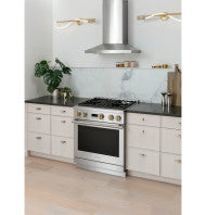 Stainless steel modern wall-mounted vent hood above a professional-style range in a contemporary kitchen setting