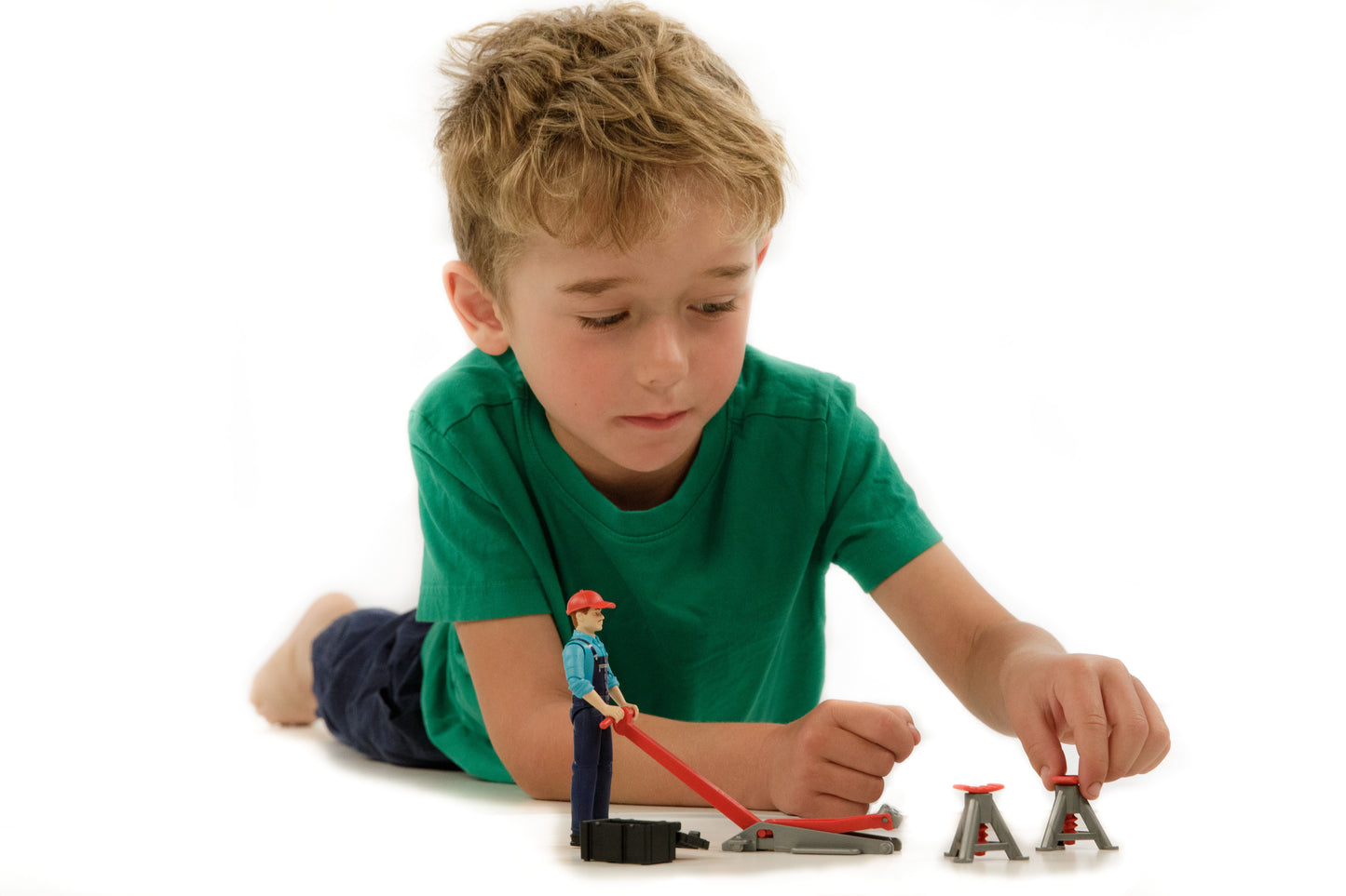 Young boy playing with Bruder Bworld man figure and repair shop accessories including jack and stands for pretend home improvement play