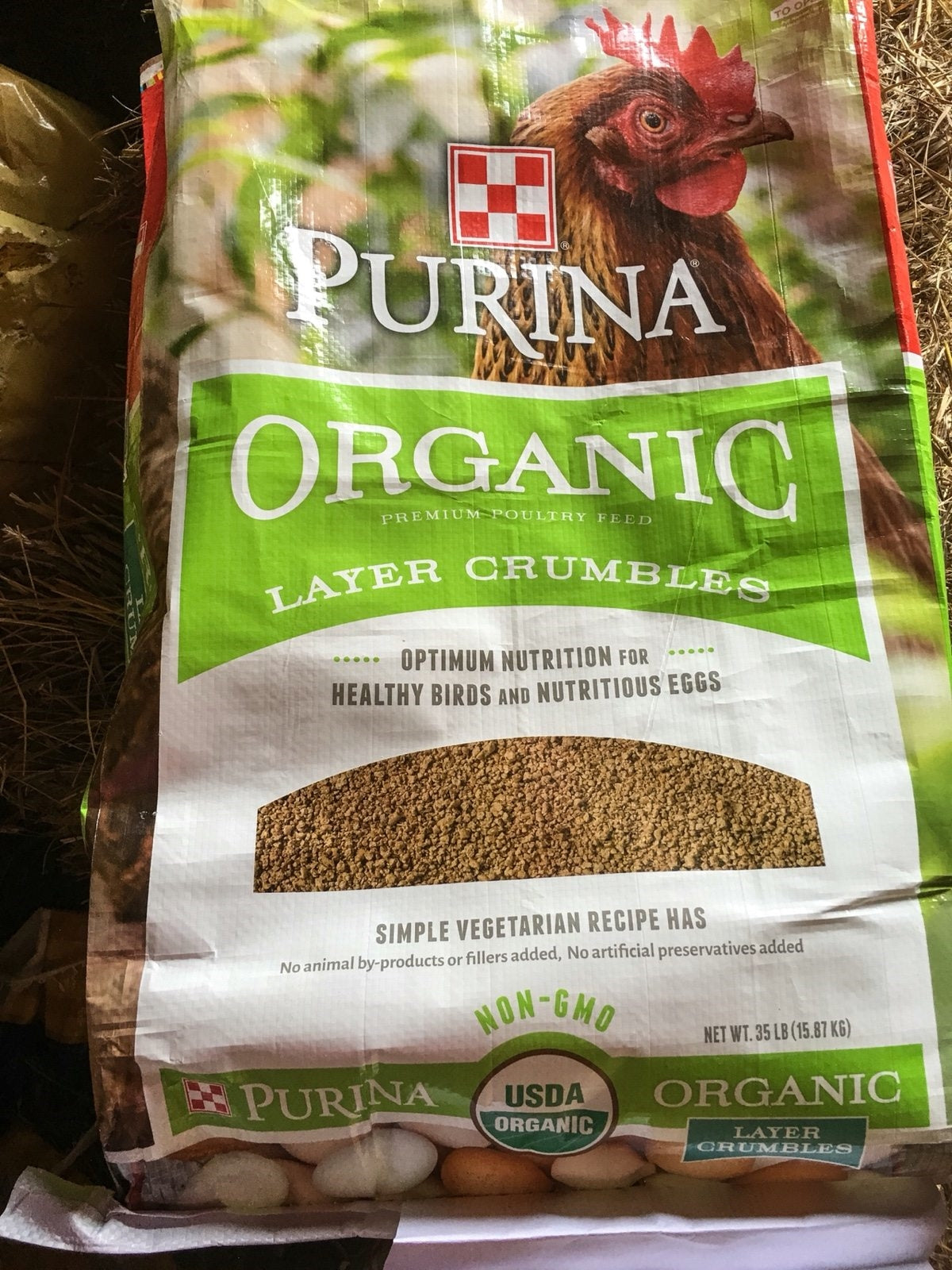 Bag of Purina organic layer crumbles poultry feed with non-GMO certification for healthy birds and eggs