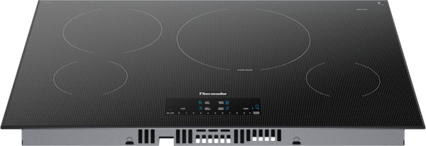 Black induction cooktop with four cooking zones and illuminated touch controls for precise temperature settings