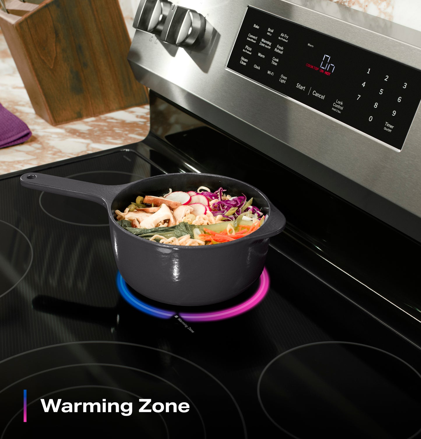 Cast iron pot with fresh vegetables cooking on an induction cooktop warming zone of a modern electric range