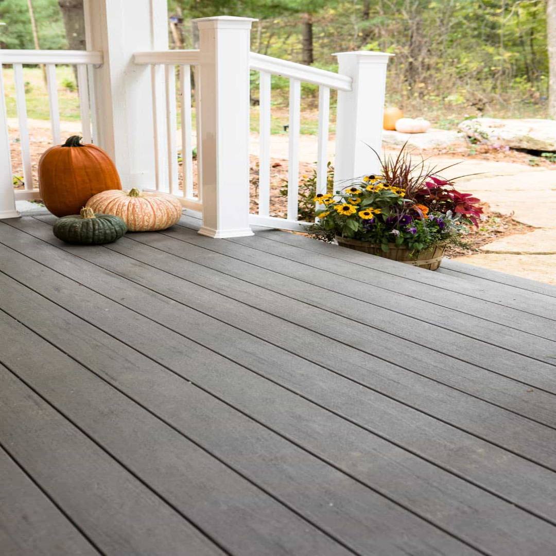 Outdoor deck featuring TimberTech decking boards with muted gray finish, seasonal pumpkins, and a flower arrangement on the porch