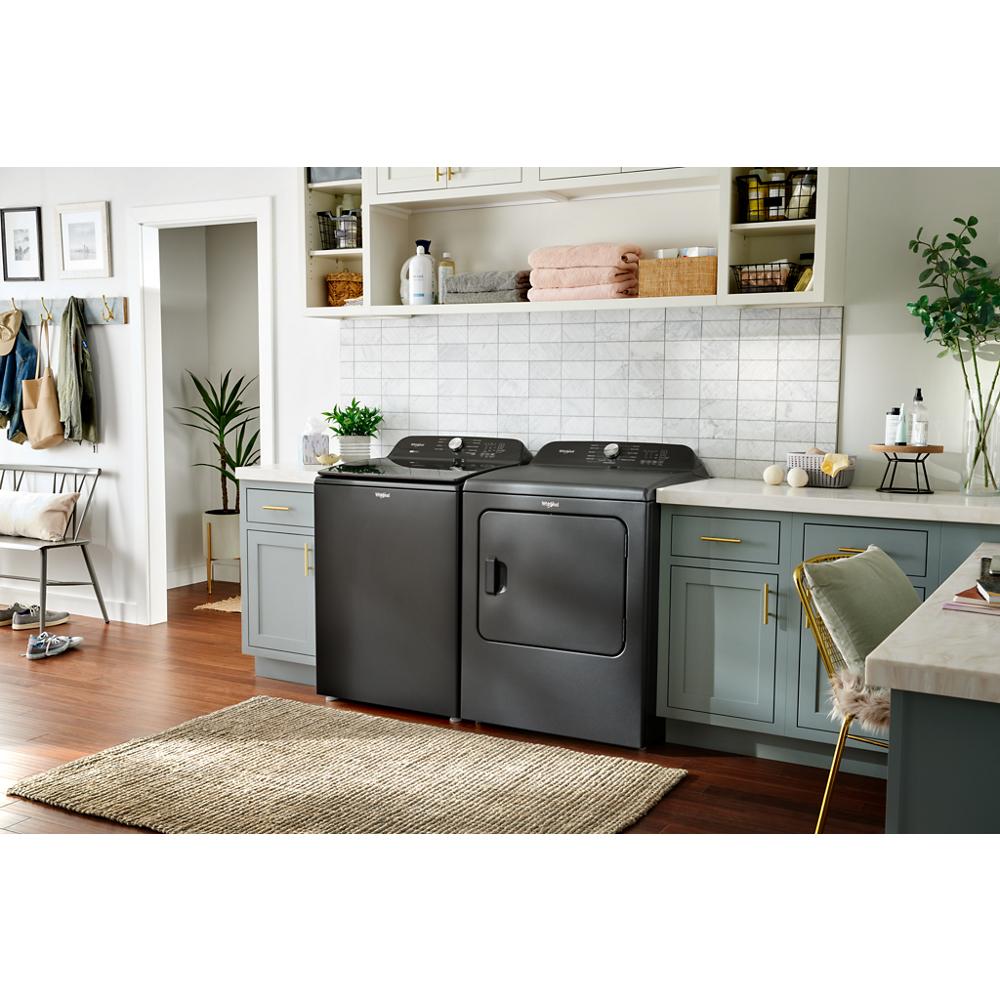 Black Whirlpool top load washer and matching dryer in bright laundry room with gray cabinetry and home decor accents