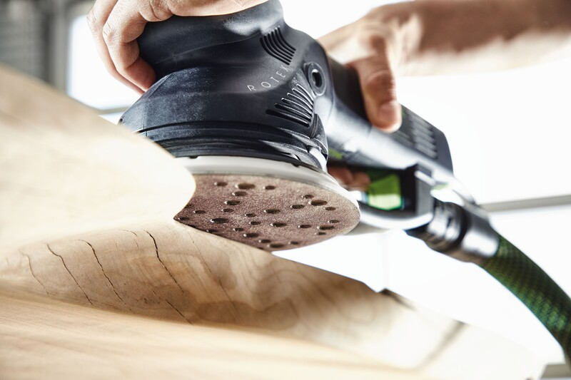 Orbital sander with dust extraction polishing a wooden surface for home improvement and woodworking projects