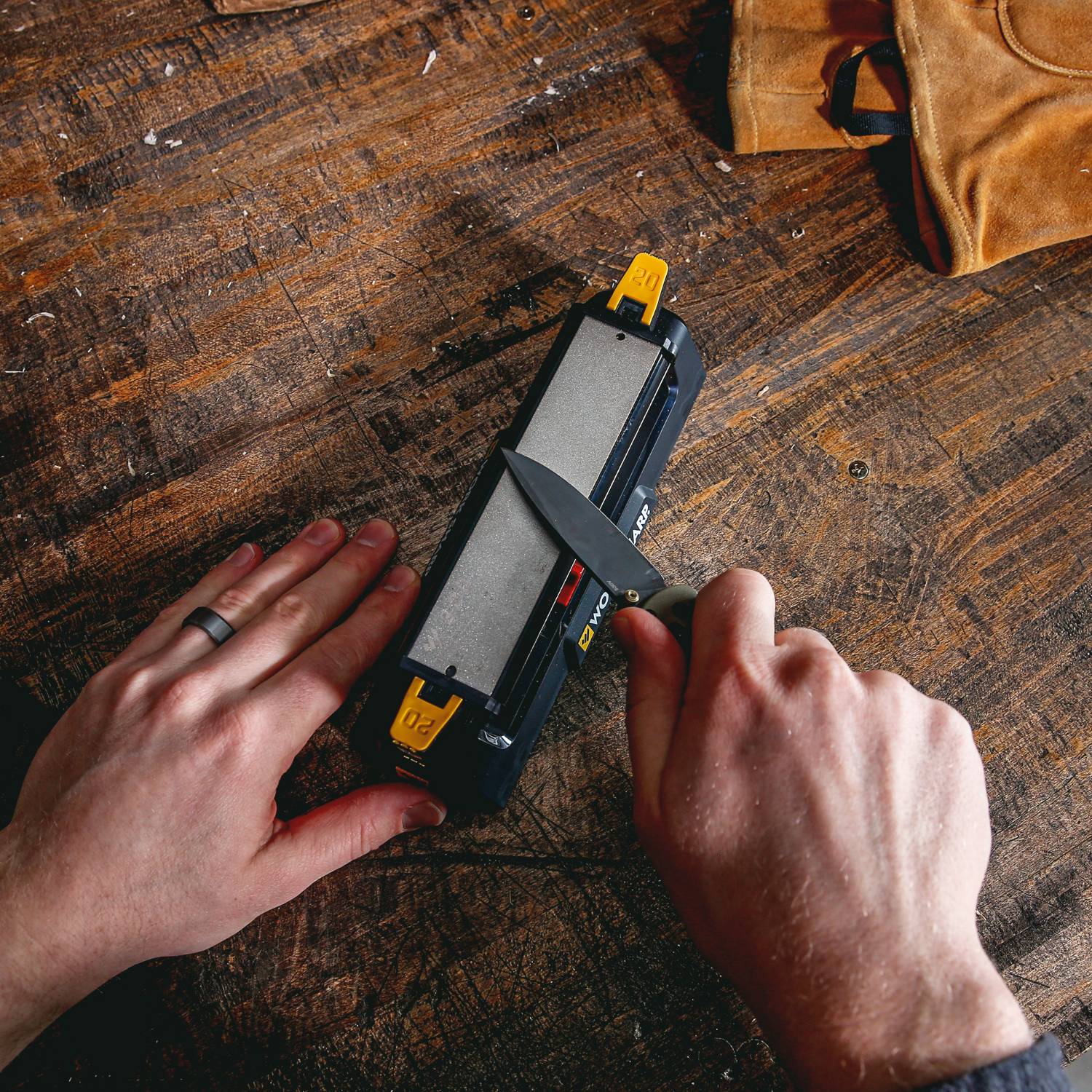 Hands sharpening a knife on a Work Sharp Benchstone tool for kitchenware and woodworking hand tools maintenance