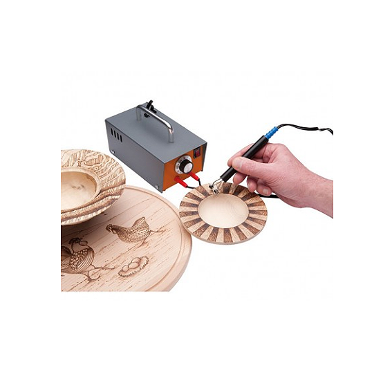 Hand using pyrography pen connected to metal machine to burn decorative patterns on wooden plates for home improvement crafts
