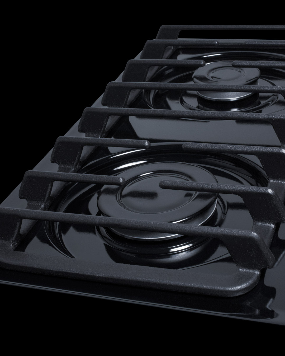 Close-up of two burners on black porcelain gas cooktop with cast iron grates in Cooktops and Kitchen & Kitchenware collections