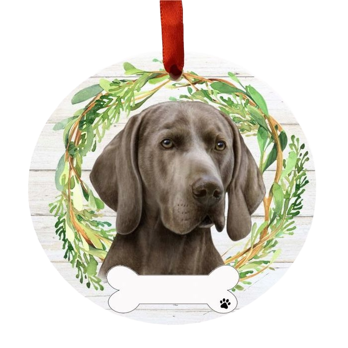 Round holiday ornament with a detailed Weimaraner dog portrait inside a green foliage wreath and red ribbon hanger