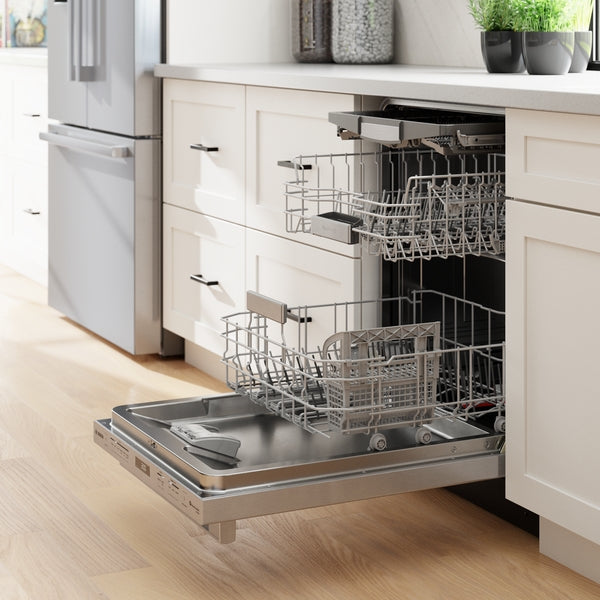 Open stainless steel dishwasher with two racks extended in a modern kitchen with light cabinetry and wood flooring