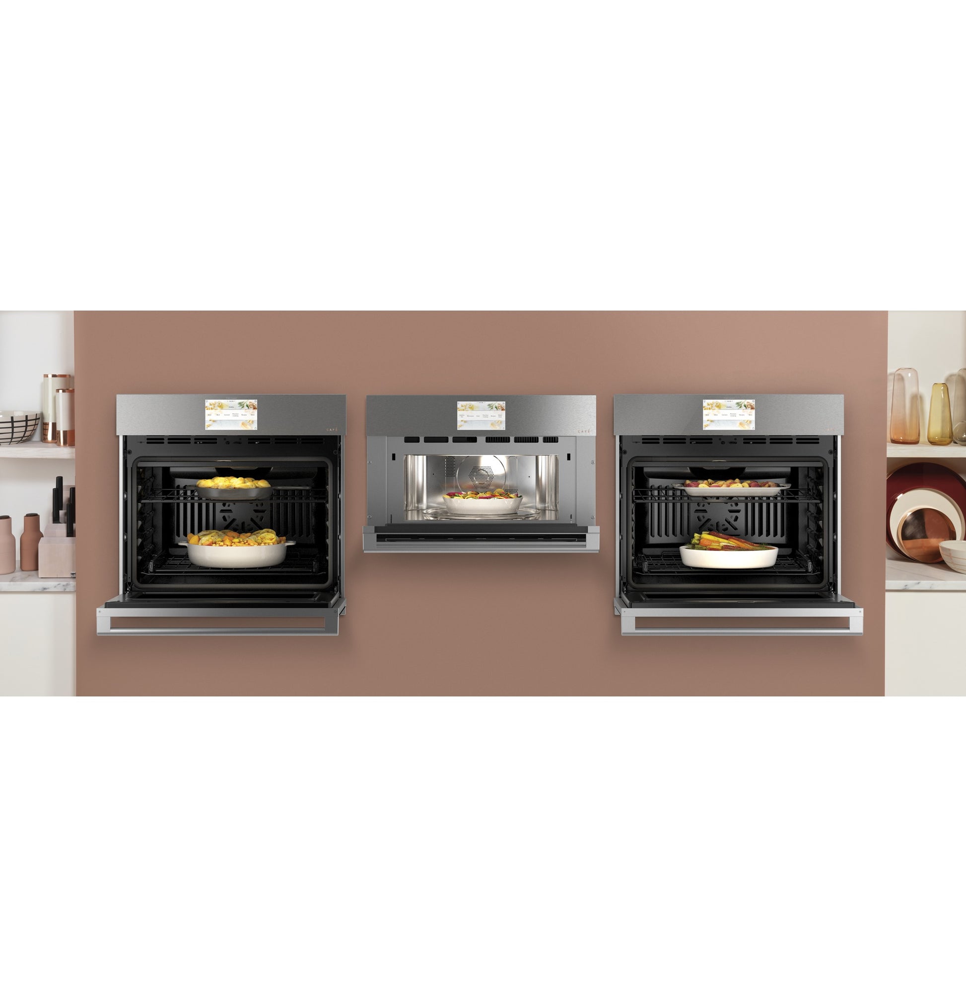Three stainless steel wall ovens in kitchen setting with baked dishes inside, part of modern appliances collection.