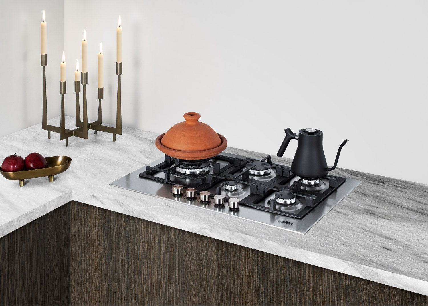 Five-burner stainless steel gas cooktop installed in marble countertop within modern kitchen and home improvement setting