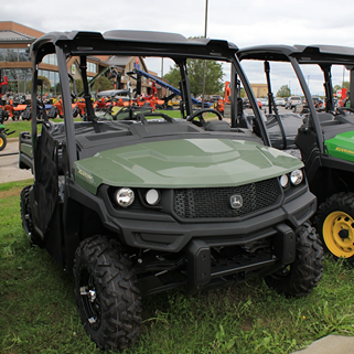 Green and black full-size crossover utility vehicle with rugged tires and protective roof for outdoor use