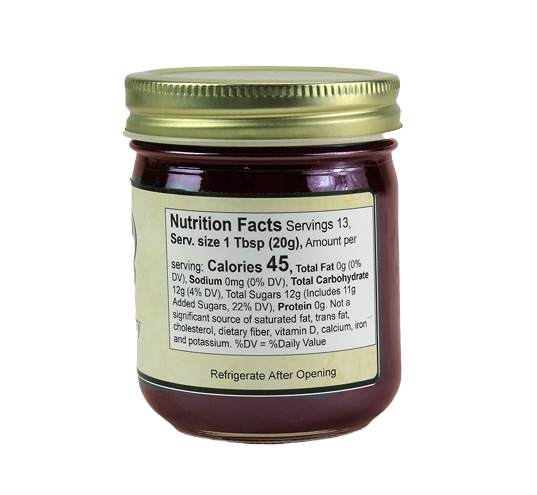 Small glass jar of seedless red raspberry jam with nutrition facts label and gold metal lid for jams and jellies collections