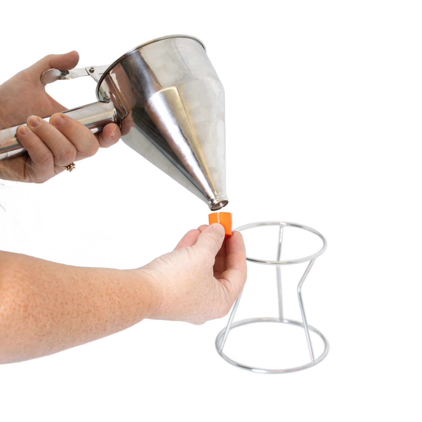 Person attaching orange silicone tip to stainless steel batter dispenser with white stand from kitchen gadgets collection under $50