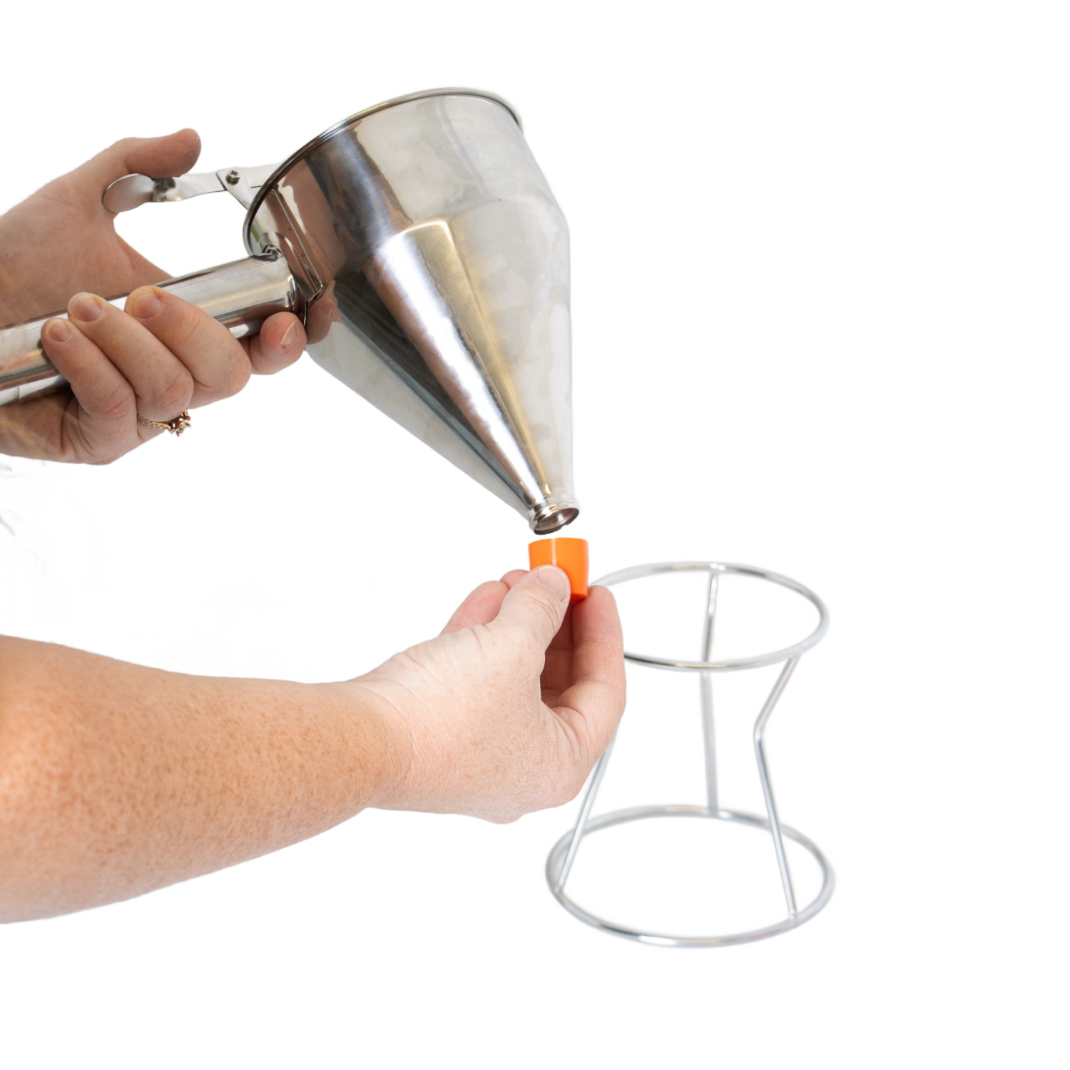 Person attaching orange silicone tip to stainless steel batter dispenser with white stand from kitchen gadgets collection under $50