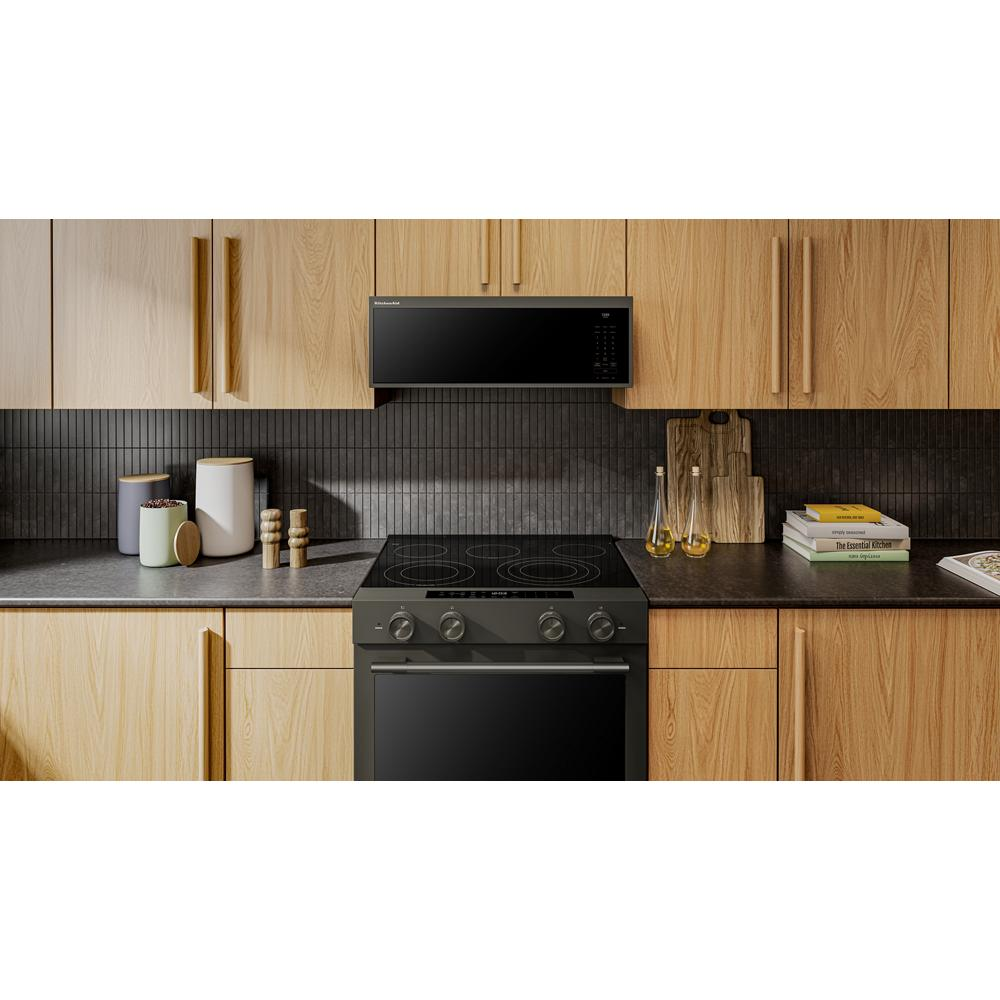 Black low profile microwave hood with digital controls installed above black electric cooktop in modern kitchen setting