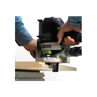 Person guiding a Festool woodworking router along the edge of a wooden board for home improvement tasks