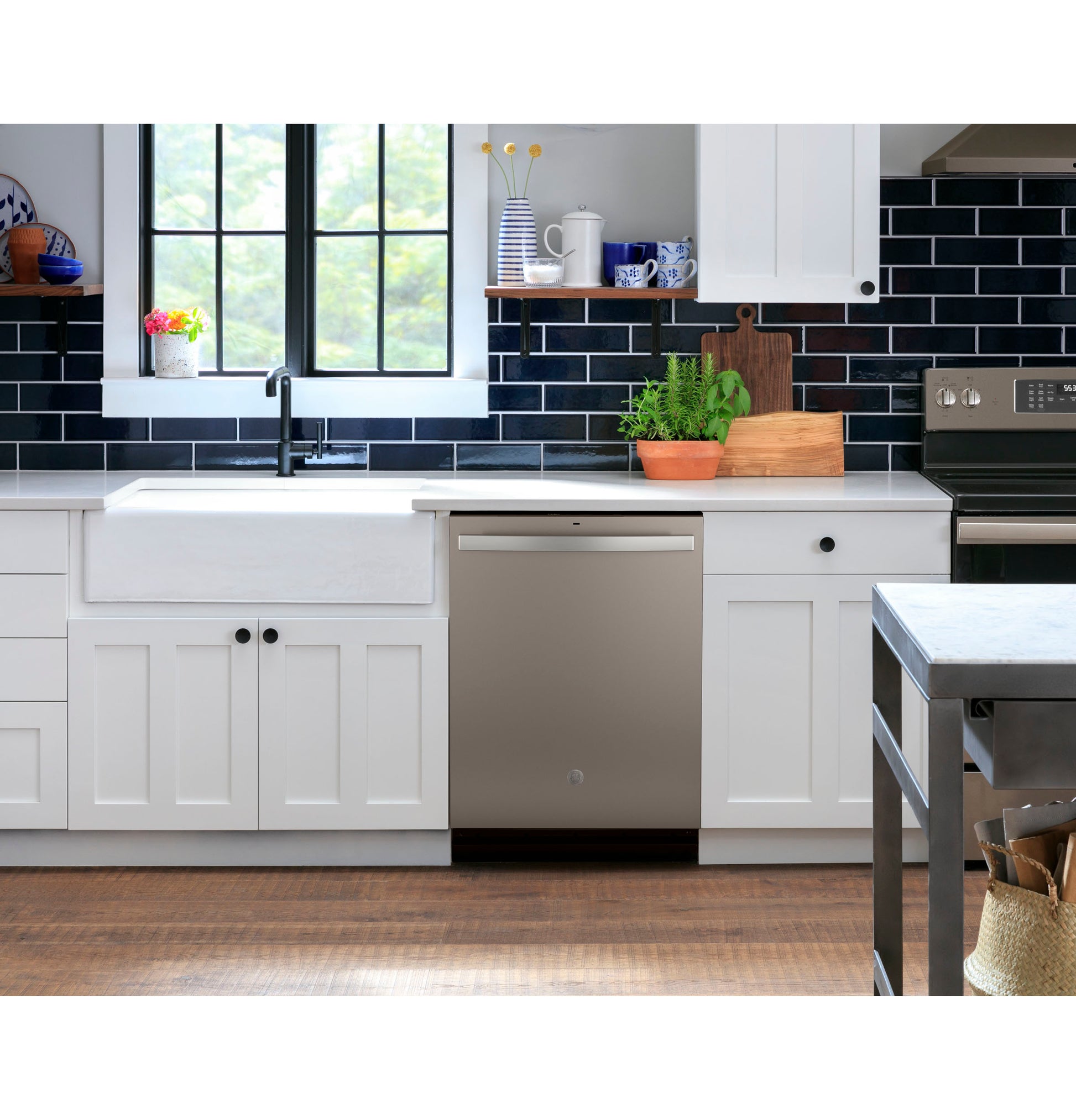 Built-in stainless steel dishwasher with top controls in bright modern kitchen with white cabinetry and dark tile backsplash