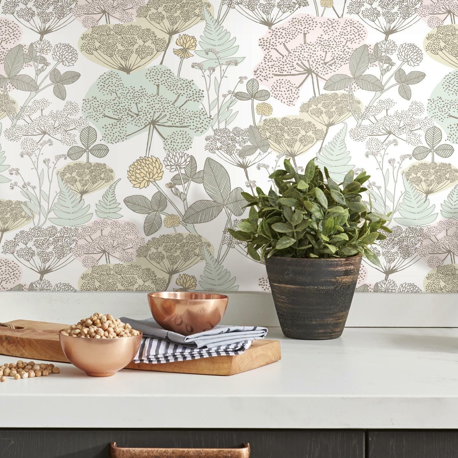 Kitchen countertop with copper bowls, wooden cutting board, green plant, and botanical peel and stick wallpaper background