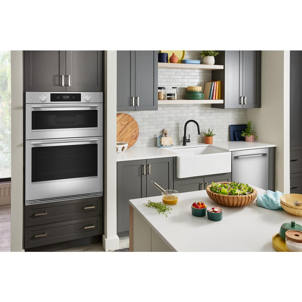 Modern kitchen featuring a built-in stainless steel smart electric combo wall oven with LED touchscreen and gray cabinetry