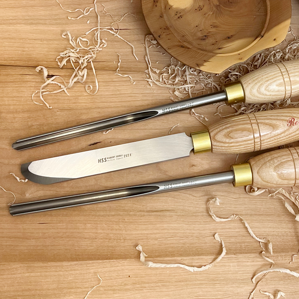 Three woodturning tools with turned wooden handles and polished metal blades for bowl shaping and carving tasks