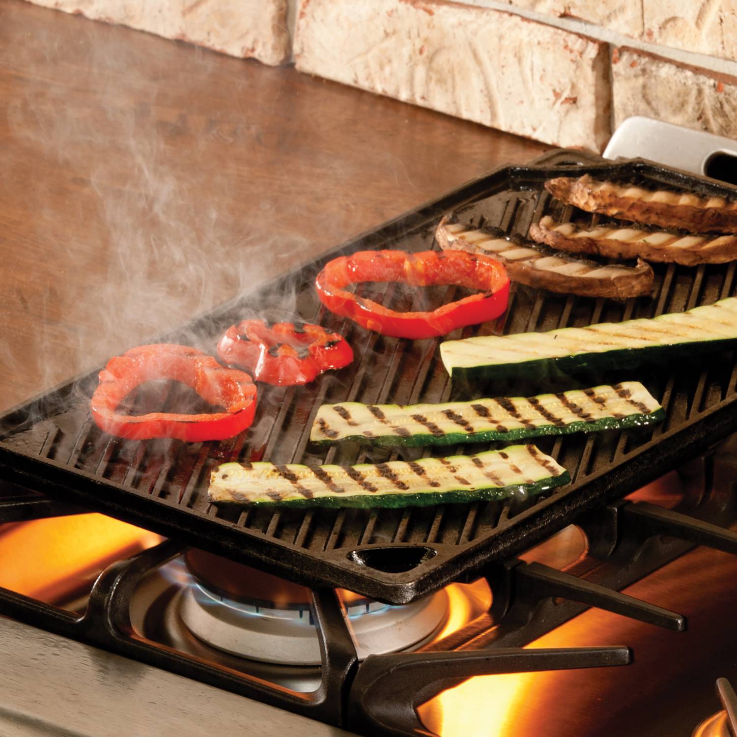 Cast iron double sided grill with ridged surface cooking vegetables over gas stove flames for home cooking tasks