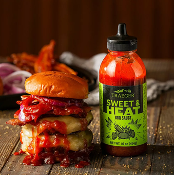 16 oz bottle of Traeger Sweet and Heat BBQ Sauce with a burger topped in spicy sauce for grilling under $50 collections