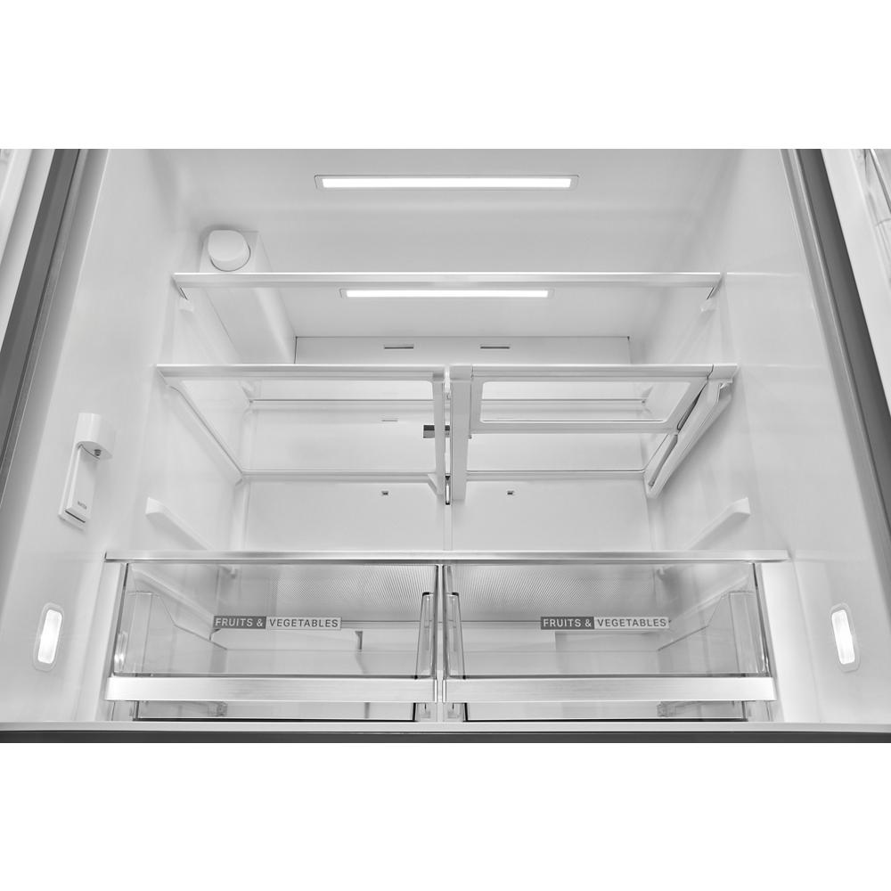 Empty refrigerator interior with adjustable glass shelves and dual fruit and vegetable drawers in modern kitchen appliance style