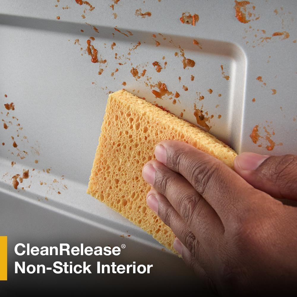 Hand using yellow sponge to easily clean non-stick interior of microwave in kitchen appliances and microwaves collection