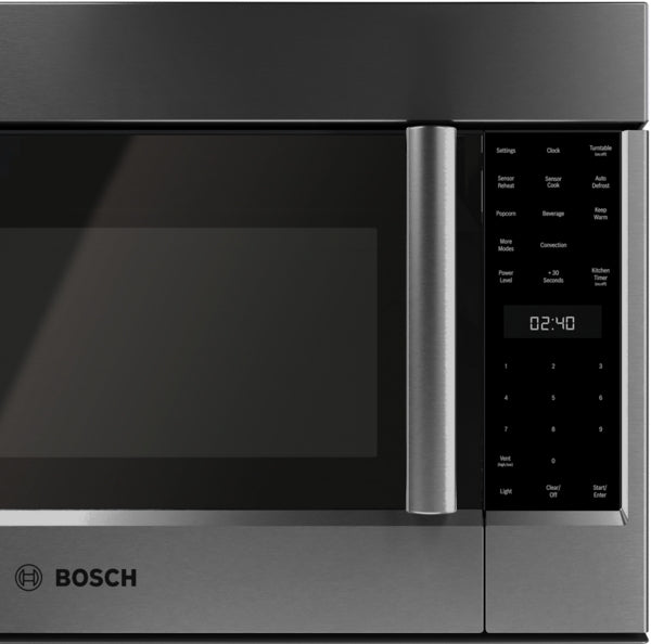Close-up view of black stainless steel microwave with touchscreen control panel and digital timer display in kitchen appliances collection