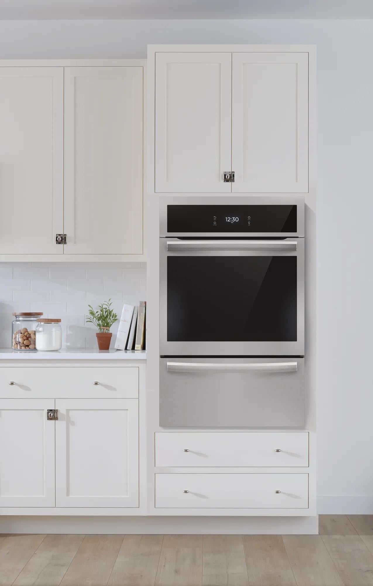 Built-in stainless steel single gas wall oven with sleek digital control panel in modern kitchen and cabinetry setting