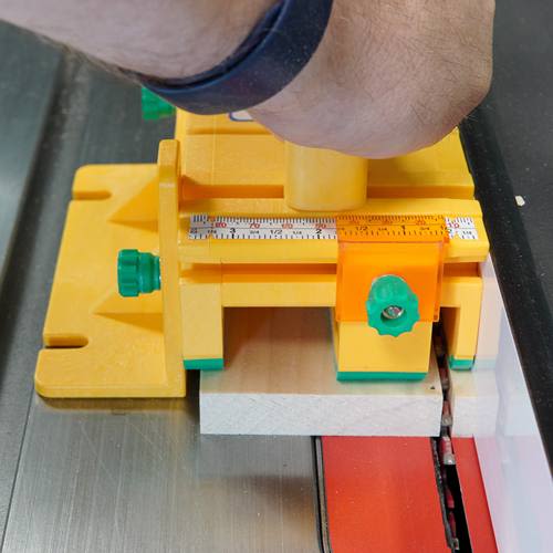 Hand operating yellow and green saw accessory with orange cursor for precise cuts in tool and power tool accessories collections