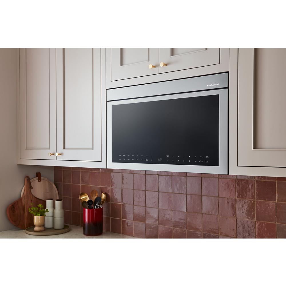 Built-in stainless steel over-the-range oven with digital touch controls installed above kitchen backsplash tiles