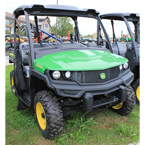 Green full-size crossover utility vehicle with custom predator terrain tires on grassy outdoor lot