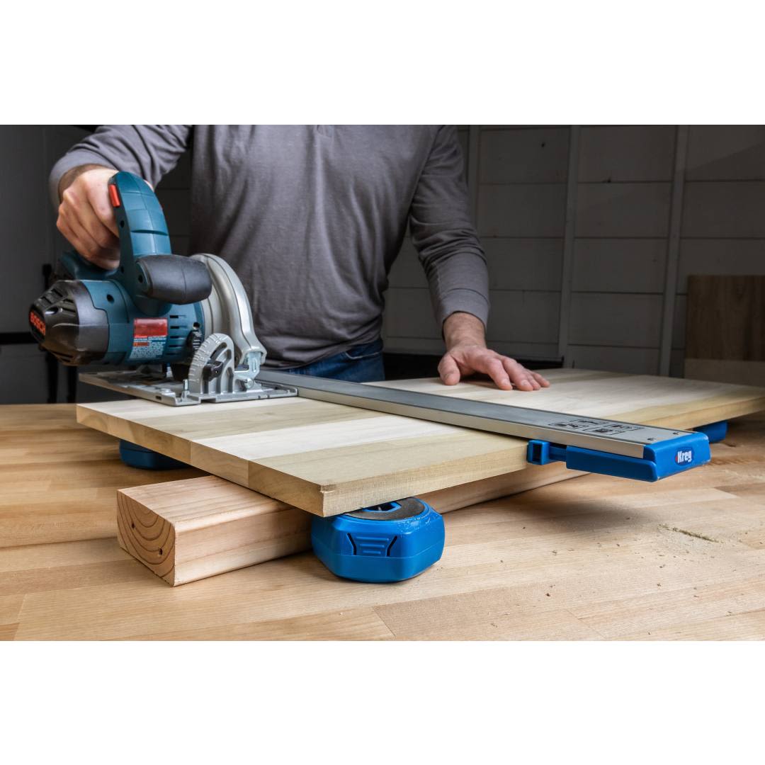 Person using blue multi-purpose project blocks to stabilize wood panel with a circular saw for home improvement tasks