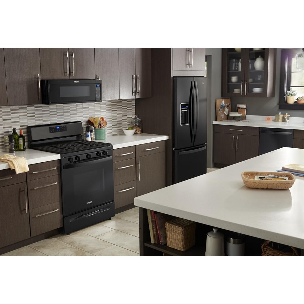 Black low profile microwave hood combination installed above matching gas stove in modern kitchen with dark cabinets and tile backsplash