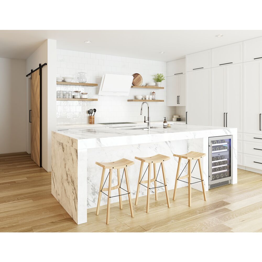 Bright kitchen with white wall mount range hood, marble island, wooden stools, and built-in wine cooler in home improvement setting