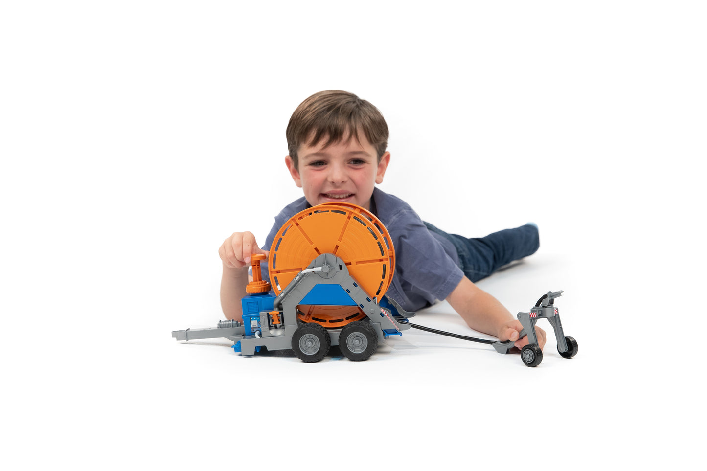 Child playing with Bruder 02034 irrigation trailer toy featuring orange reel and gray-blue frame in Vehicles & Remote Controlled Toys collection