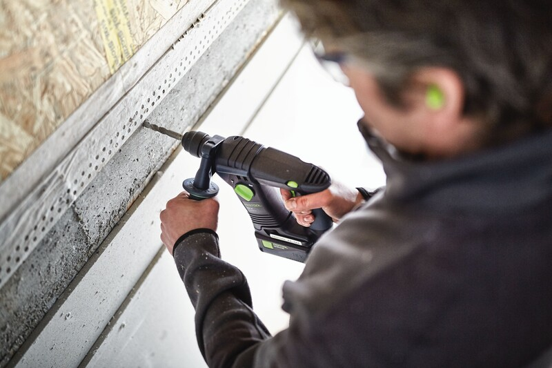 Man using a drill with a side handle attachment for better grip in home improvement and tool accessory projects
