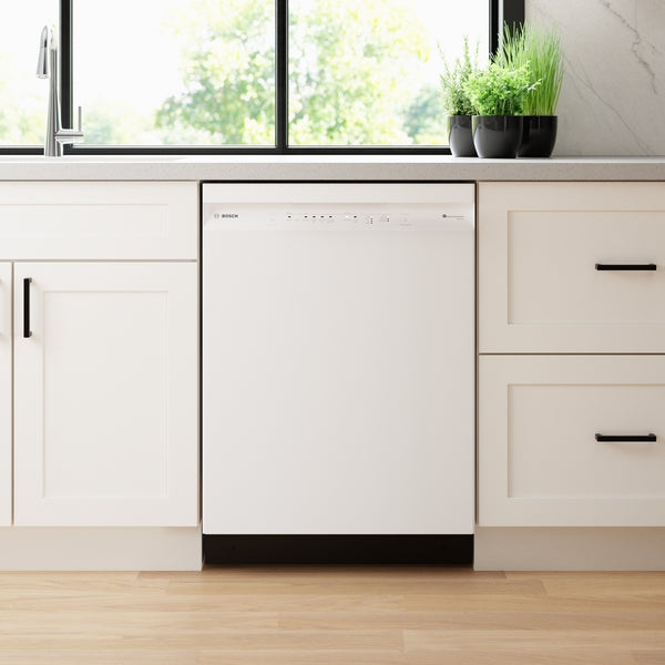 White 24-inch Bosch dishwasher integrated into modern kitchen cabinetry with black handles and potted plants on counter