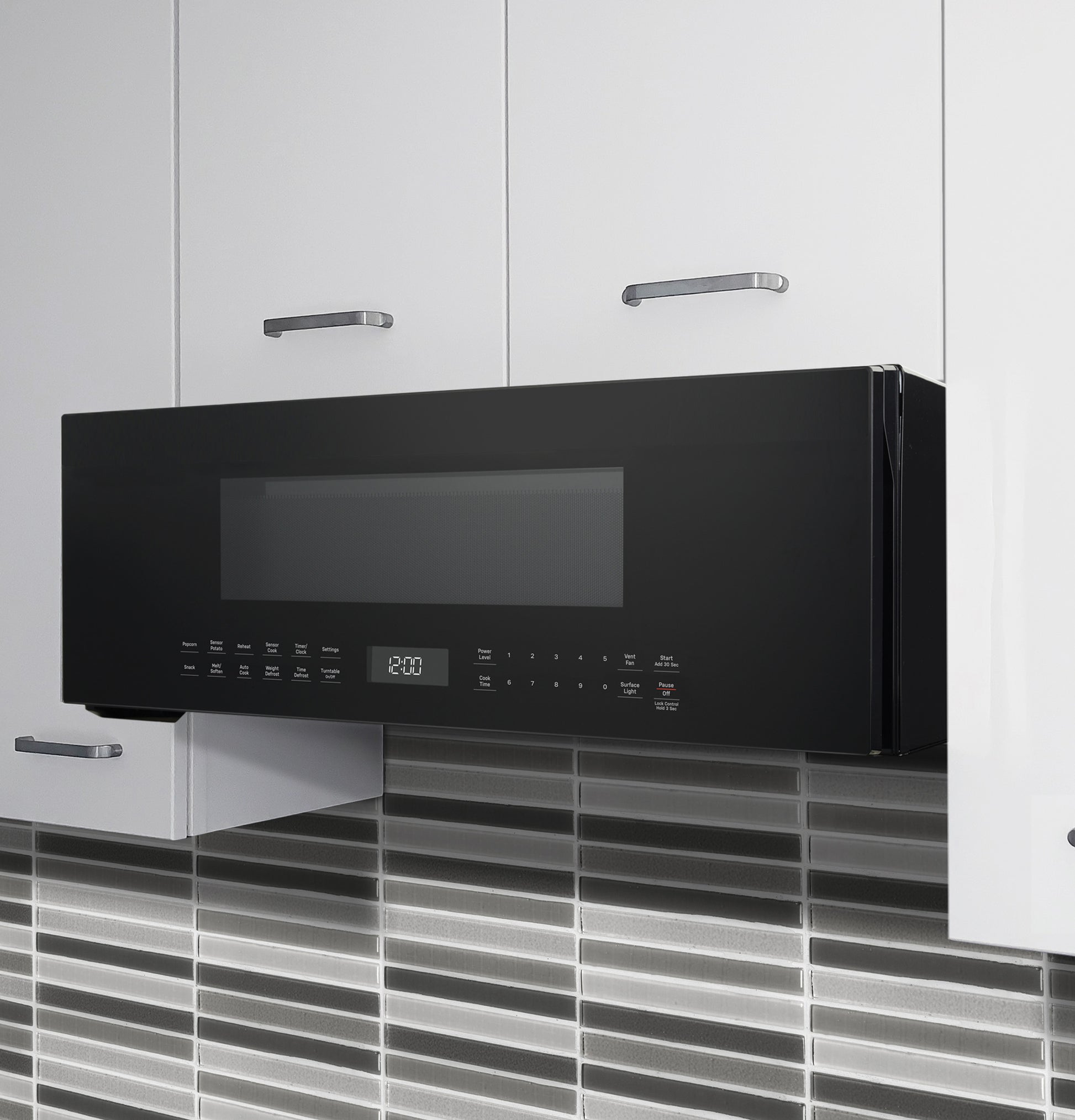 Black over-the-range low profile microwave with digital display and sensor controls in modern kitchen setting