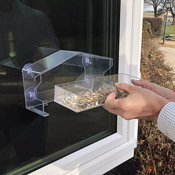 Clear plastic window bird feeder with suction cups and removable tray for easy refilling bird seeds on glass surface