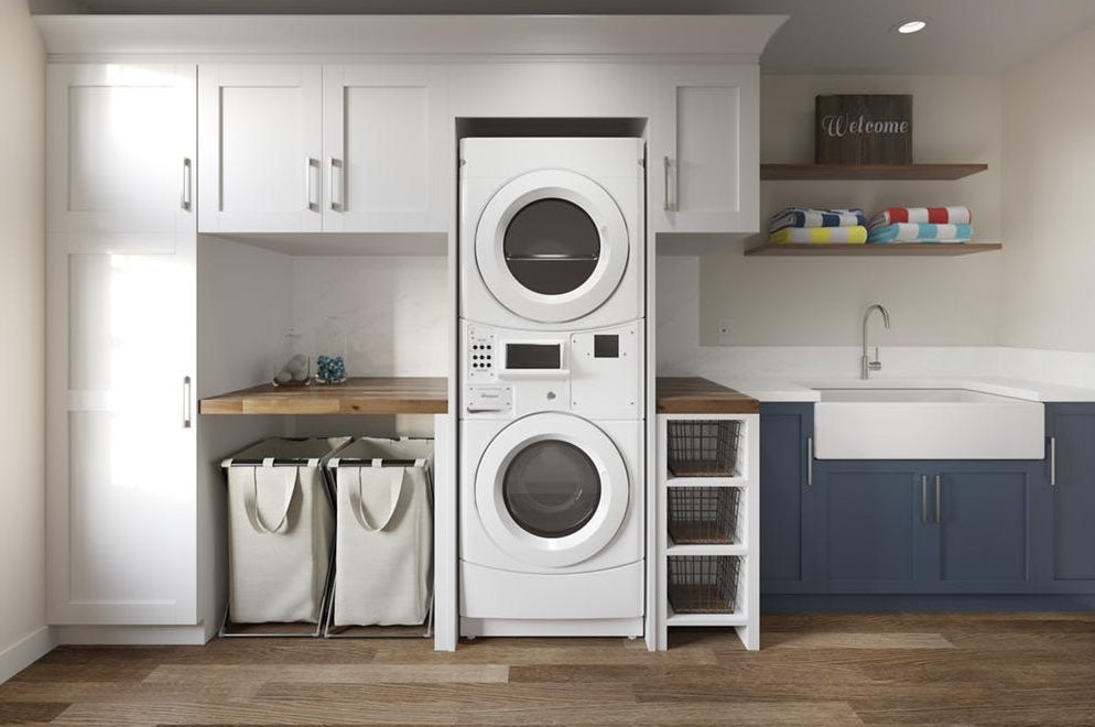 Commercial stack washer and dryer combo with card reader slot in modern laundry room with cabinetry and storage shelves