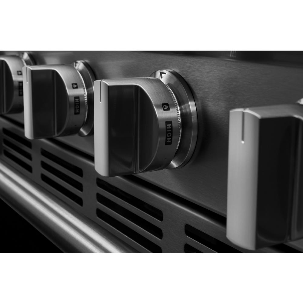 Close-up of stainless steel gas range control knobs set against a brushed metal surface in kitchen appliances collection