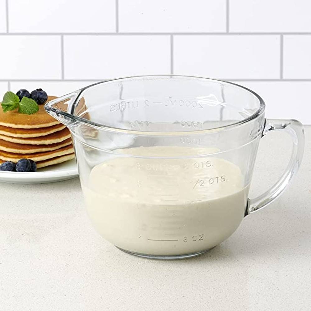 Clear glass batter bowl with handle and measurable markings, shown with pancake batter in kitchenware collections under $50